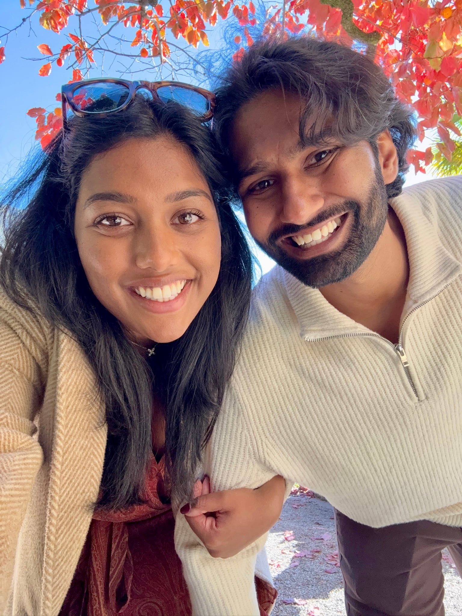 Esha & Anish taking a selfie among bright autumn leaves