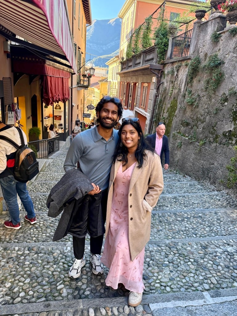 Esha & Anish on a cobblestone street in Bellagio, Italy